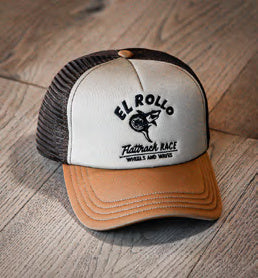 Vorderansicht der Wheels & Waves El Rollo Cap mit cremefarbener Front, braunem Schirm und schwarzem Aufdruck auf Holz.