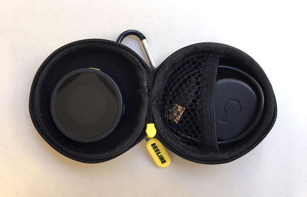 Geöffnetes Beeline Moto Carry Case mit Navigationsgerät links und Ladezubehör im Netzfach rechts.