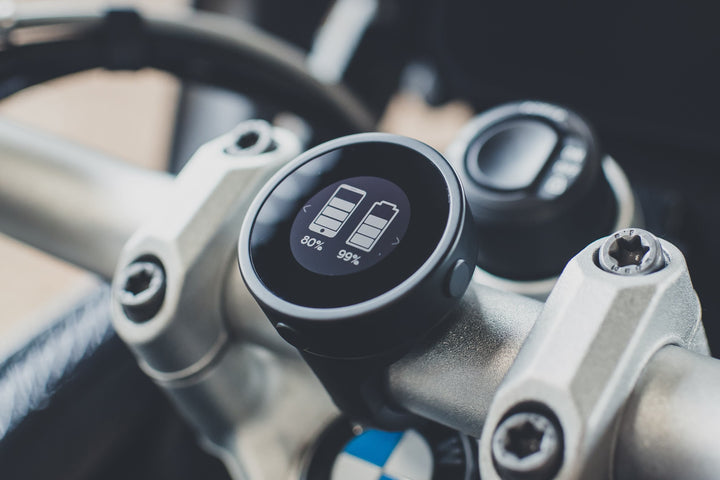 Beeline Moto Original mit Batterieanzeige auf der Lenkerklemme zwischen den Lenkerböcken eines Motorrads.