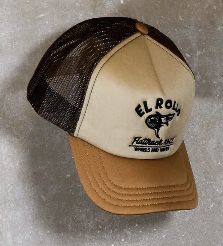 Wheels & Waves El Rollo Trucker Cap mit cremefarbener Front, braunem Schirm, dunklem Netz und schwarzem El-Rollo-Motiv.